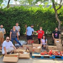 Group of people in front of crates of fresh produce
