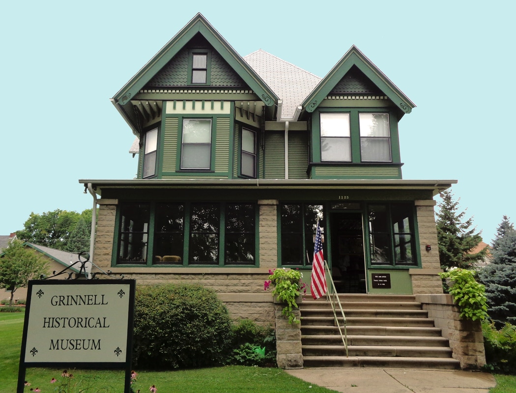 Grinnell Historical Museum: a large green Victorian home with its name on a sign out front